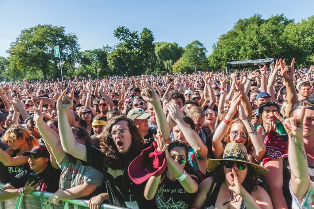Publiek steekt de handen in de lucht tijdens een dagfeest
