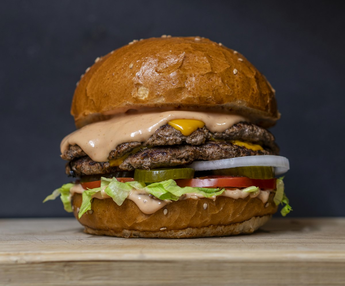 Dubbele cheeseburger met sla, tomaat en augurk