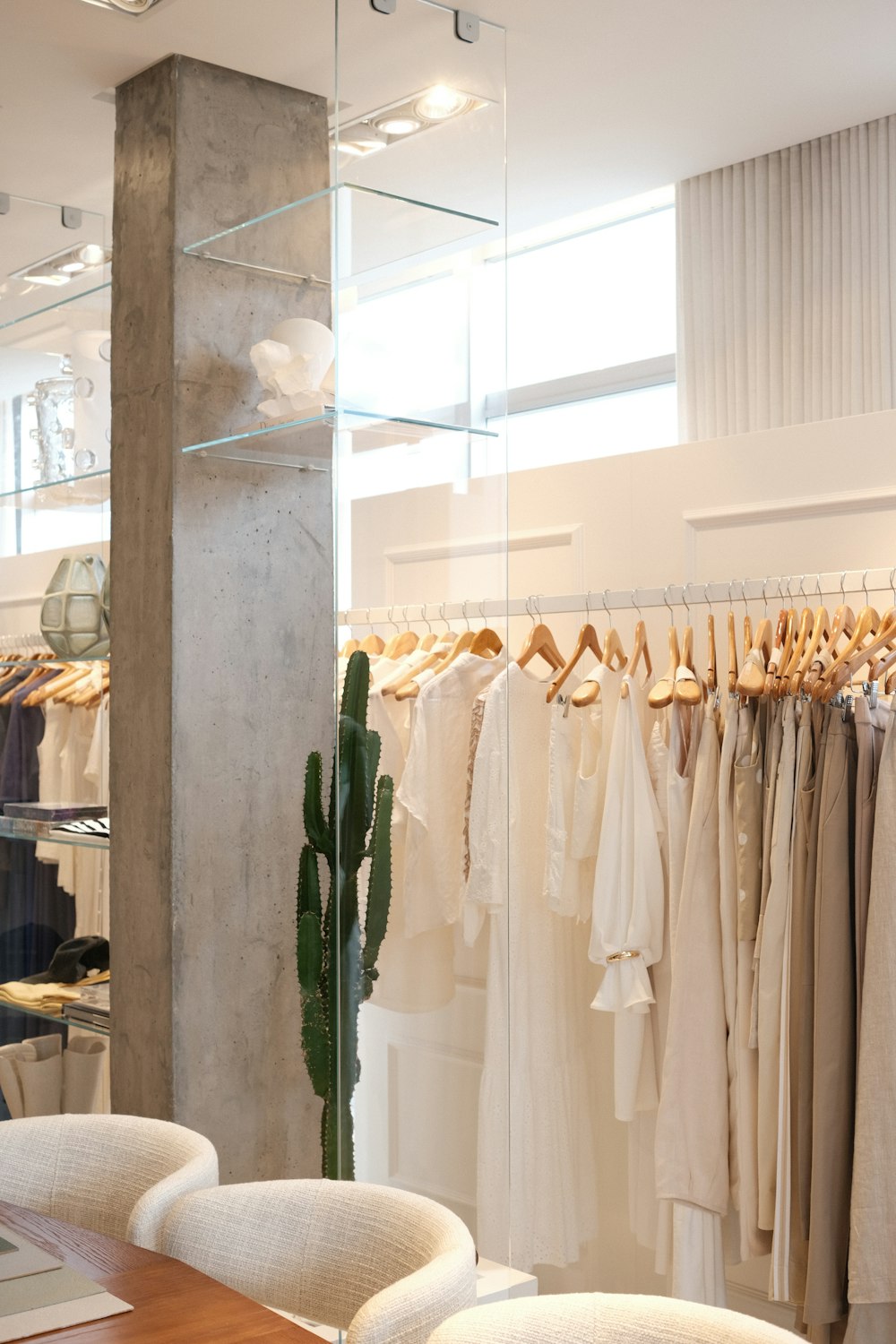 Lichte luxe boetiek met kleding aan houten hangers