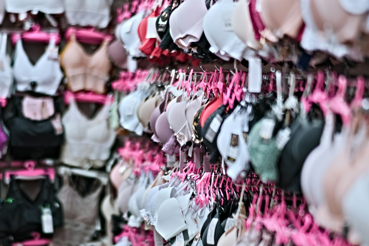 Bh's in verschillende kleuren aan hangers in een lingeriewinkel