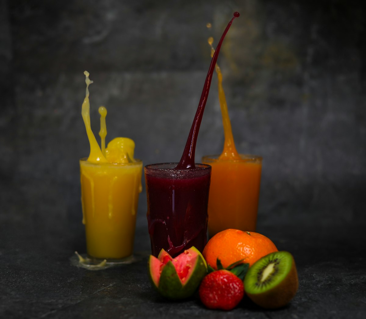 Drie glazen verse fruitsap met vers fruit