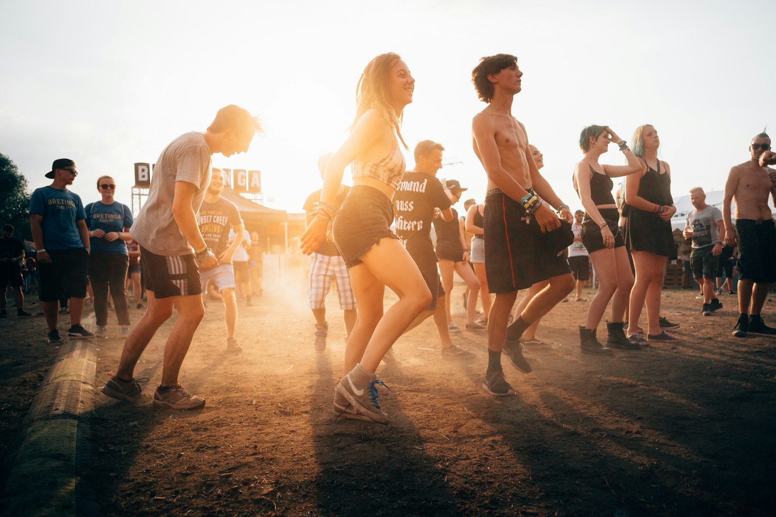 Mensen dansen bij zonsondergang op een dancefeest in de buitenlucht