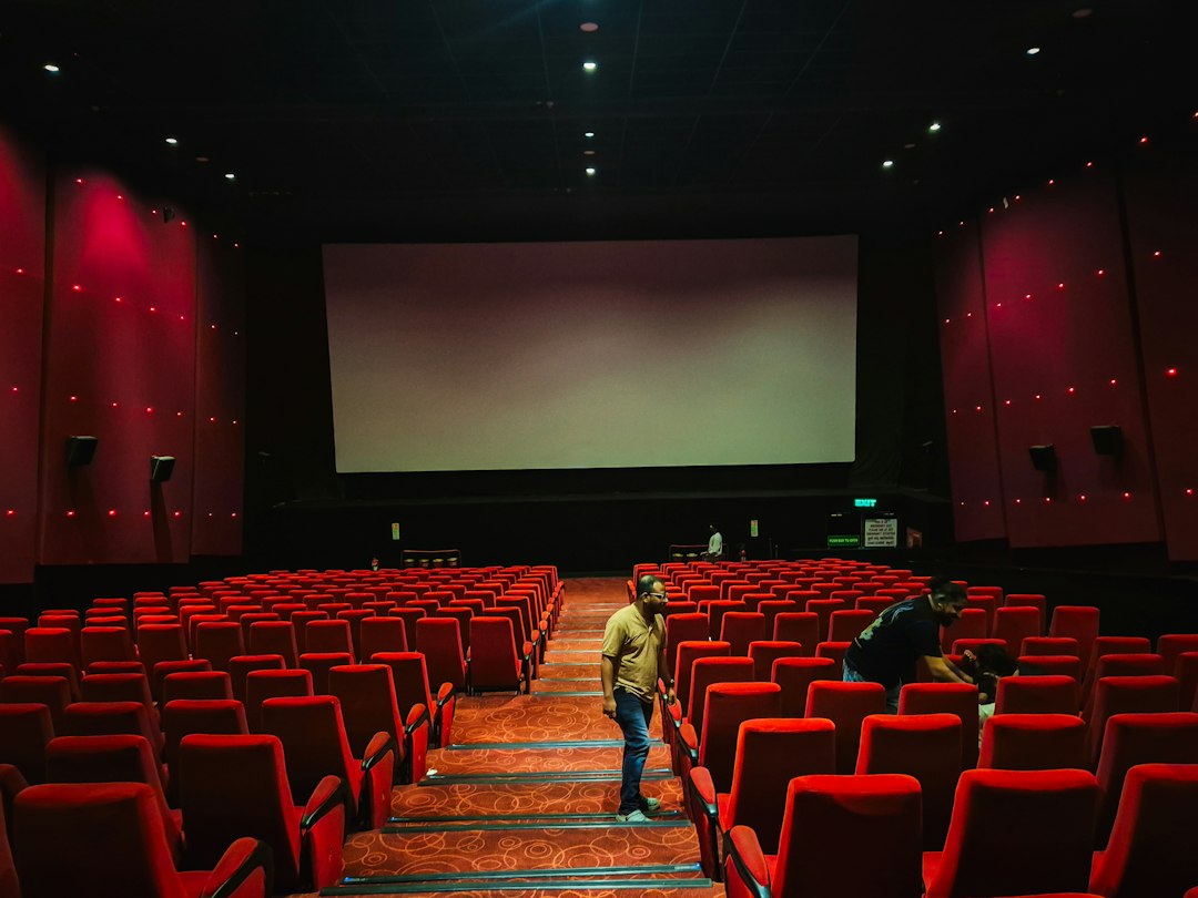 Lege bioscoopzaal met rode stoelen en een groot filmdoek