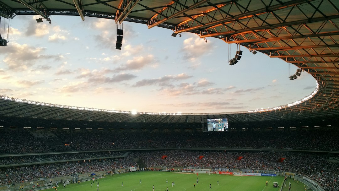 Voetbalstadion overdag met een groen speelveld en lege tribunes