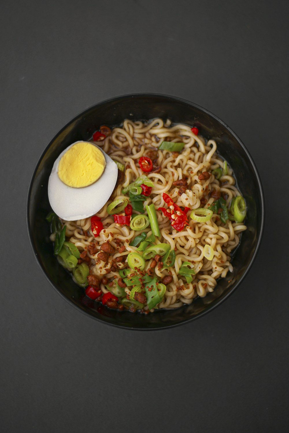 Kom ramen met noedels, ei, lente-ui en rode peper